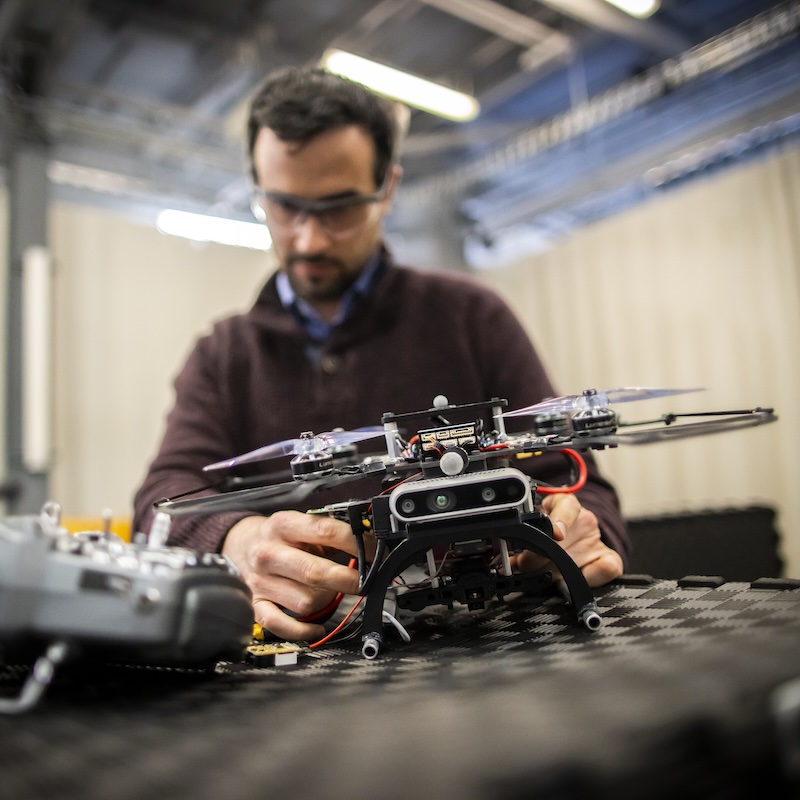 A researcher examines a drone at the GRASP lab at Penn Engineering