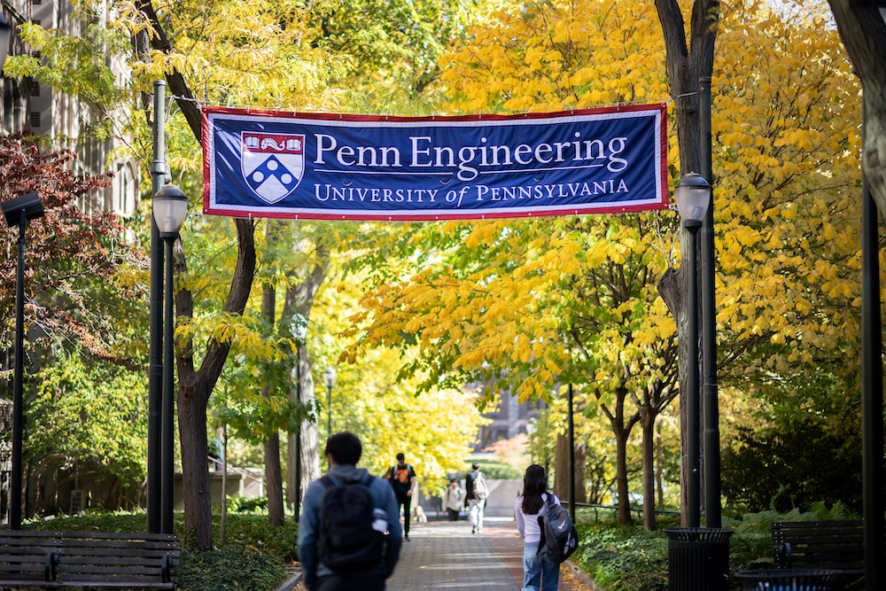 Students walk by the Penn Engineering banner on campus