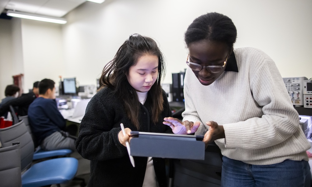 Two students in the Penn Engineering lab viewing a screen together